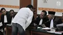 Terdakwa Hercules Rosario Marshal berkonsultasi dengan penasihat hukum saat menjalani sidang perdana di PN Jakarta Barat, Rabu (16/1). Hercules mengaku berencana melangsungkan umrah usai persidangan kasusnya selesai. (Merdeka.com/Iqbal Nugroho)