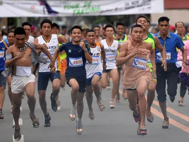 Sejumlah peserta berlari meninggalkan garis start menggunakan sepatu heels saat mengikuti "Tour De Takong" di Marikina, Manila, Filipina, 26 November 2016. Balap lari stiletto itu merupakan bagian dari festival sepatu tahunan. (REUTERS/Ezra Acayan)