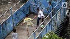 Sejumlah anak bermain sepak bola dalam bak truk di kawasan Cengkareng, Jakarta, Rabu (23/2/2022). Minimnya lahan bermain di kawasan tersebut membuat anak-anak memanfaatkan tempat yang bukan semestinya untuk bermain bola. (Liputan6.com/Johan Tallo)