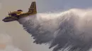 Sebuah pesawat Royal Moroccan Air Force Canadair memadamkan kebakaran hutan di wilayah Chefchaouen, Maroko, 17 Agustus 2021. Petugas pemadam kebakaran Maroko berjuang untuk memadamkan dua kebakaran hutan saat negara tersebut dilanda gelombang panas. (FADEL SENNA/AFP)