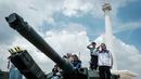 Pengunjung berfoto bersama peralatan militer yang dipamerkan selama Pameran Alat Utama Sistem Pertahanan (Alutsista) Tentara Nasional Indonesia (TNI) di Monumen Nasional (Monas) di Jakarta pada 21 September 2025. (YASUYOSHI CHIBA/AFP)