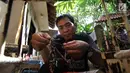 Perajin, Inoe Farhand mengecek miniatur sepeda dari pelepah pisang hasil buatannya di Pamulang, Tangerang Selatan, Kamis (10/1). Kerajinan tangan buatan  Inoe dijual dengan harga antara Rp 500 ribu hingga Rp 2 juta. (Merdeka.com/Arie Basuki)