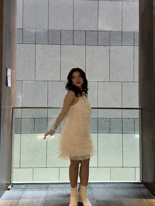 Marsha Aruan mengenakan dress bling-bling putih dipadukan boots warna serasi. Ia pun mengenakan gelang friendship. [@aruanmarsha]