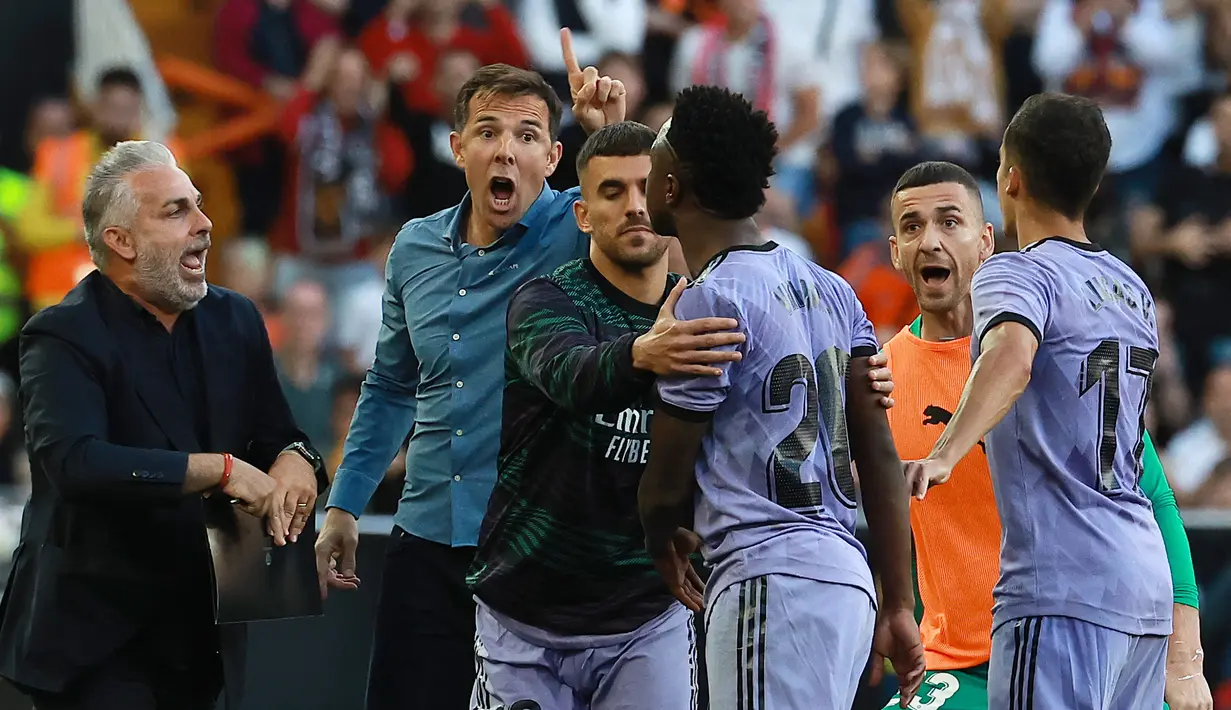 Striker Real Madrid, Vinicius Junior terlibat keributan dengan tim ofisial Valencia setelah ia dikartu merah wasit pada laga pekan ke-35 Liga Spanyol 2022/2023 di Mestalla Stadium, Valencia, Senin (22/5/2023) dini hari WIB. (AFP/Jose Jordan)