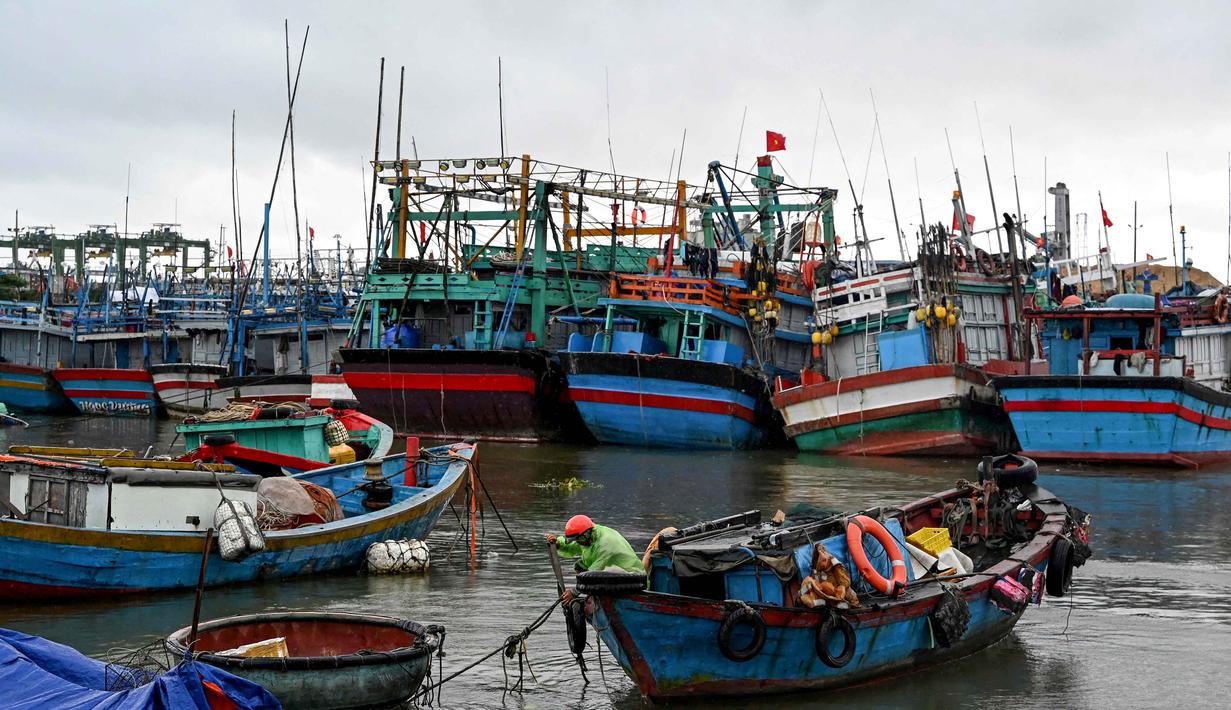 Para ahli meteorologi di Pusat Peringatan Topan Gabungan (JTWC) militer Amerika Serikat melaporkan bahwa badai tersebut telah kembali menguat saat mendekati wilayah tengah Vietnam. Tampak dalam foto, seorang pria mengikat perahu untuk melindunginya dari dampak Topan Kalmaegi di Pelabuhan Perikanan Quy Nhon, Provinsi Gia Lai, Vietnam Tengah, pada 6 November 2025. (Nhac NGUYEN/AFP)