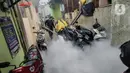 Petugas melakukan pengasapan (fogging) untuk memberantas perkembangbiakkan nyamuk Demam Berdarah Dengue (DBD) di pemukiman padat penduduk, Jakarta, Rabu (18/5/2022). Menghadapi musim pancaroba yang menjadi perkembangbiakkan nyamuk Aedes Agypty penyebab penyakit DBD, warga melakukan fogging di wilayah padat penduduk. (Liputan6.com/JohanTallo)