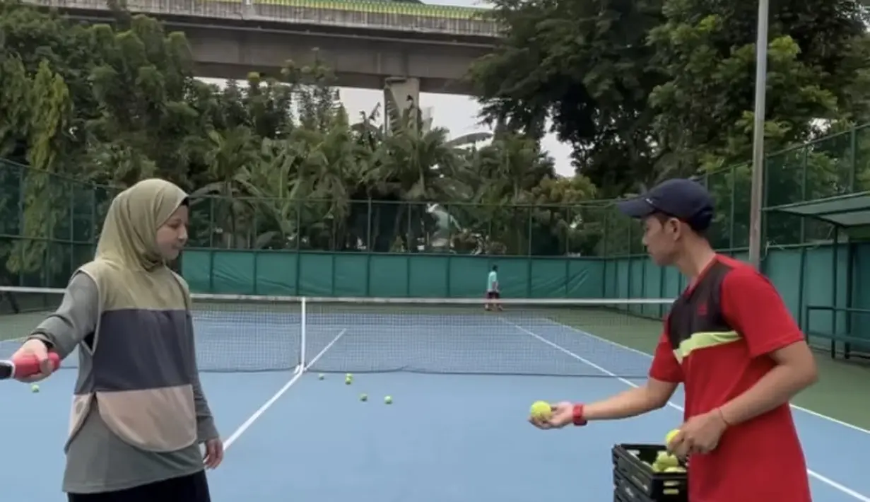 Rompi hijab tersebut dipadukan dengan manset lengan panjang abu-abu, serta bawahan rok sekaligus celana warna hitam yang panjang. (@natasharizkynew)