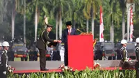 Presiden Jokowi menerima kertas sebelum menyampaikan pidato pada peringatan HUT ke-71 Bhayangkara di Monas, Jakarta, Senin (10/7). Sebanyak 2.408 personel gabungan Polri, TNI, Satpol PP dan Pramuka terlibat dalam upacara ini. (Liputan6.com/Angga Yuniar)