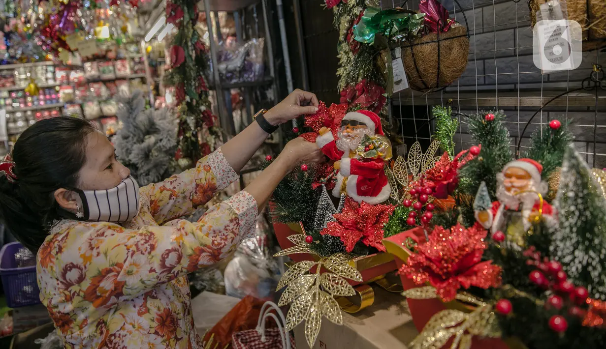 Sejumlah calon pembeli memilih pernak-pernik Natal di Pasar Asemka, Jakarta, Kamis (10/12/2020). Menurut seorang penjual, omset penjualan pernak-pernik bertema Natal turun drastis sekitar 50% dari biasanya karena pandemi Covid-19. (Liputan6.com/Faizal Fanani)