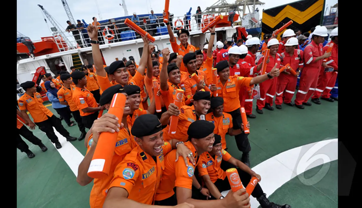 Petugas tim SAR berpose bersama saat penyerahan bangkai badan pesawat AirAsia QZ8501 di Pelabuhan Tanjung Priok, Jakarta, Senin (2/3/2015). (Liputan6.com/Faizal Fanani)