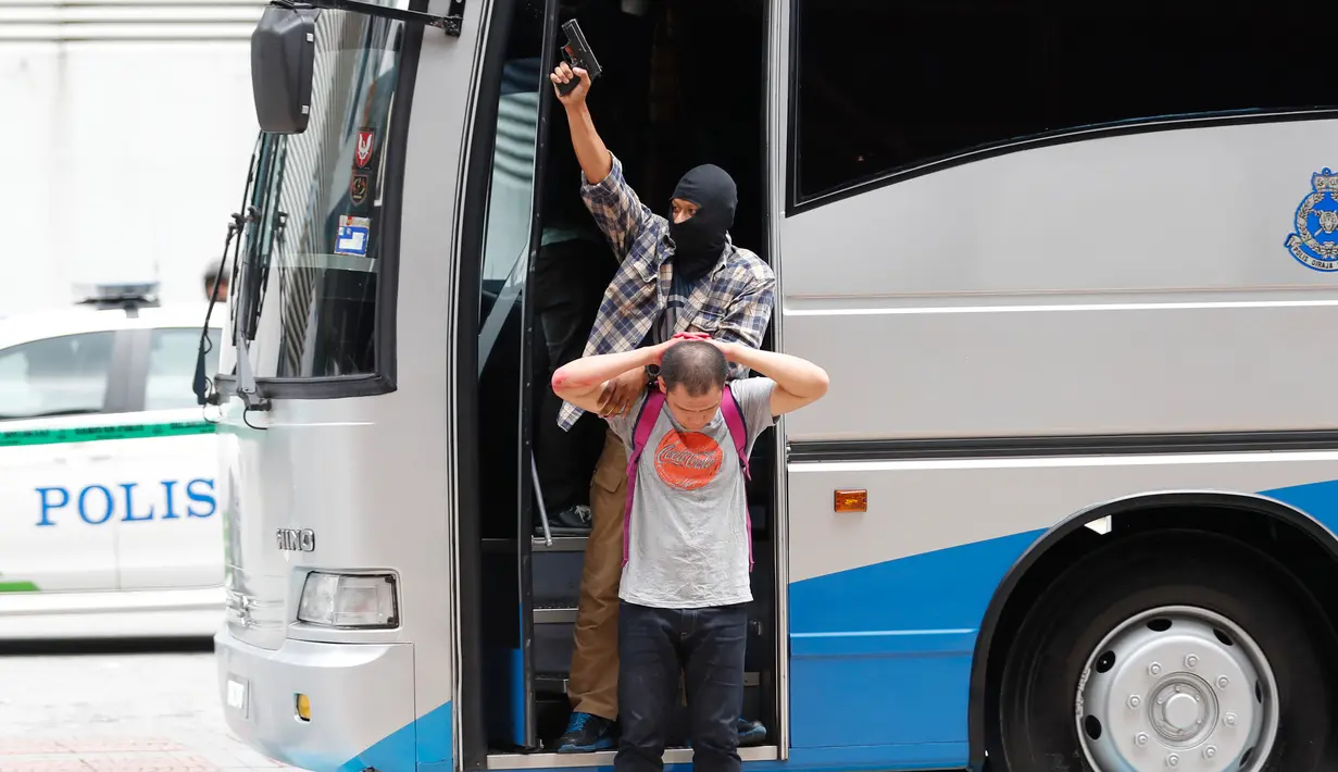 Anggota Petugas Polisi Malaysia Raya yang bertindak sebagai teroris menyandra seorang penonton saat latihan persiapan SEA Games Asia Tenggara di Kuala Lumpur, Malaysia, (20/7). (AP Photo/Vincent Thian)