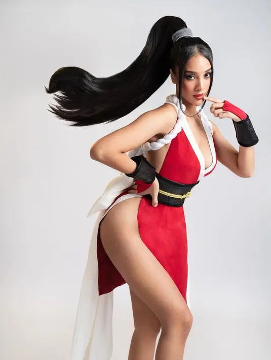 Anya tampil totalitas mengenakan dress merah dengan belahan paha tinggi dan bagian dada yang terbuka. Dress merah dengan list putih tersebut dipadukan obi hitam dan tali emasnya.. [@anyageraldine]