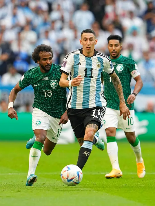 Pemain Argentina Angel Di Maria (tengah) mengontrol bola menjauhi pemain Arab Saudi Yasser Al-Shahrani (kiri) pada pertandingan sepak bola Grup C Piala Dunia 2022 di Stadion Lusail, Lusail, Qatar, Selasa (22/11/2022). Arab Saudi mengalahkan Argentina dengan skor 2-1. (AP Photo/Ebrahim Noroozi)