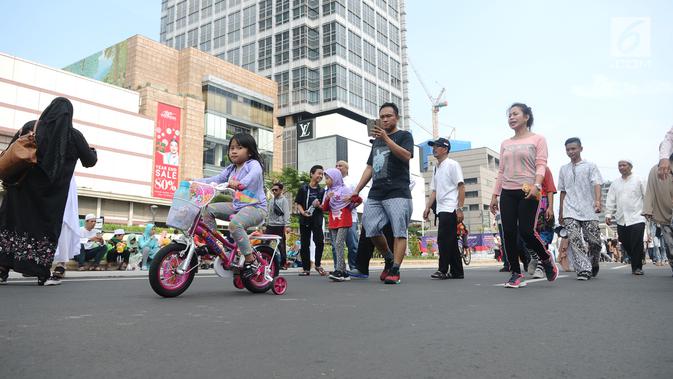 Seorang anak perempuan bersepeda saat Car Free Day (CFD) di kawasan Jakarta, Minggu (2/12). Warga tetap memadati area Car Free Day  dari Bundaran HI-Sudirman meskipun ada aksi Reuni 212. (Liputan6.com/Angga Yuniar)
