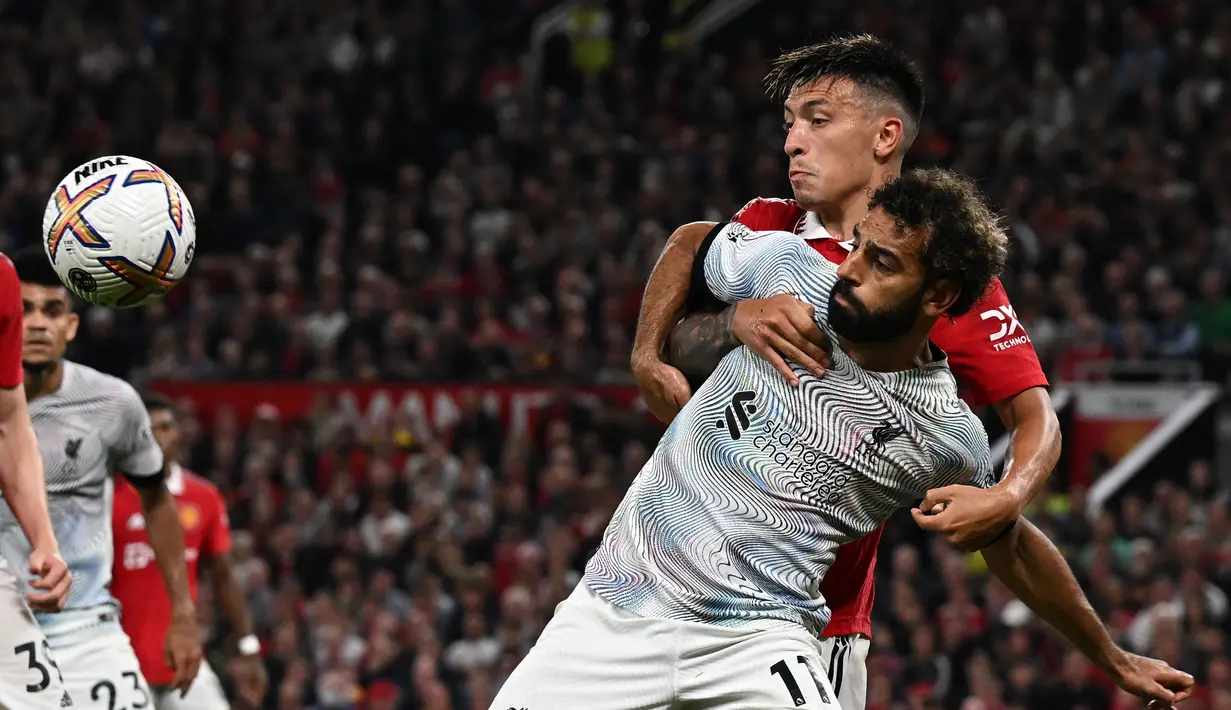 Striker Liverpool Mohamed Salah bersaing dengan bek Manchester United Lisandro Martinez (kanan) pada laga pekan ketiga Liga Inggris di Stadion Old Trafford, Selasa (23/8/2022) dini hari WIB. Secara luar biasa MU menang perdana di Liga Inggris musim 2022/2023 dengan mengalahkan rival abadi Liverpool 2-1. (Photo by Paul ELLIS / AFP)