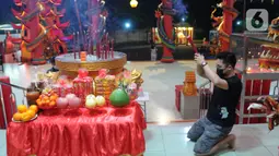 Warga Tionghoa memanjatkan doa sambil membawa hio (dupa) pada malam tahun baru Imlek 2573 di  Vihara Kwan In Thang, Pondok Cabe, Tangerang Selatan, Senin (31/1/2022). Perayaan malam Imlek berlangsung khidmat dan sederhana di tengah merebaknya covid-19 varian omicron. (merdeka.com/Arie Basuki)