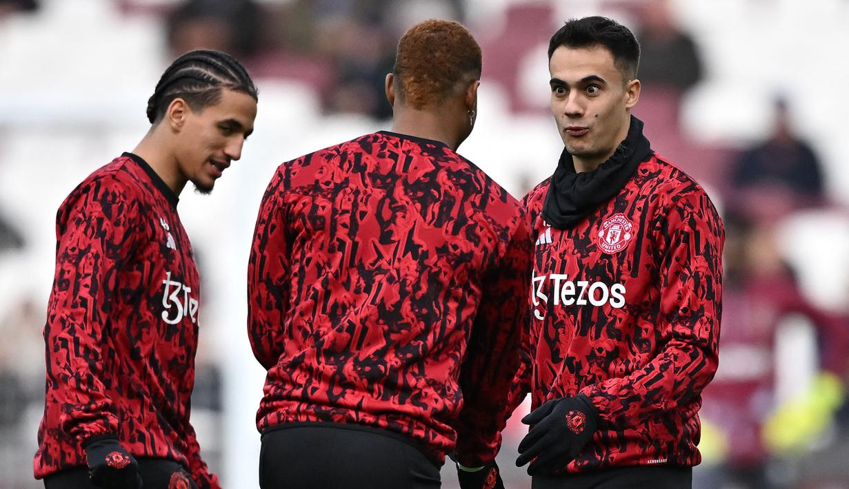 Pemain Manchester United, Sergio Reguilon (kanan) bercengkrama dengan rekannya saat melakukan pemanasan sebelum laga lanjutan Liga Inggris 2023/2024 melawan West Ham di Old Trafford, Manchester, Inggris, 23 Desember 2023. (AFP/Ben Stansall)