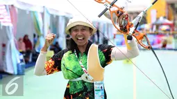 Pemanah Jatim Eka Yuliana mengangkat tangan usai memastikan meraih emas kelas Recurve Women Individual di Lapangan Panahan Si Jalak Harupat, Kab Bandung, Rabu (21/9). Di final, Yuliana mengalahkan Rina D Puspitasari. (Liputan6.com/Helmi Fithriansyah)