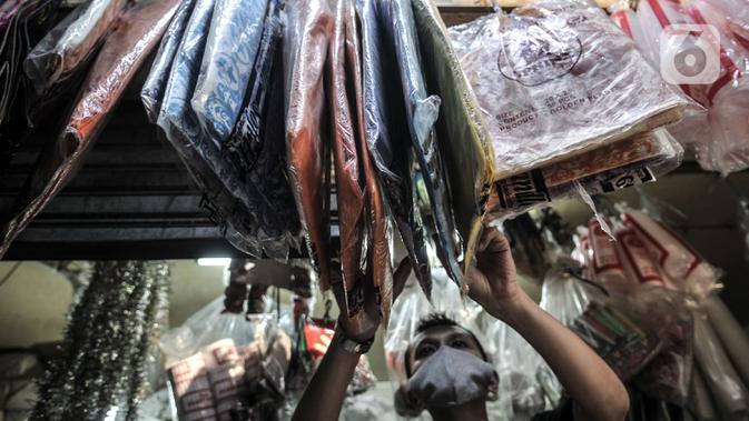 Abdullah merapikan kantong ramah lingkungan yang juga dijual di Pasar Tebet Barat, Jakarta, Selasa (30/6/2020). Meski dirinya juga telah menjual kantong ramah lingkungan, namun minat beli masyarakat tetap masih rendah. (merdeka.com/Iqbal S Nugroho)