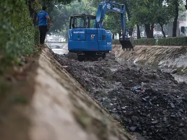 Petugas Sudin SDA Setiabudi menggunakan alat berat untuk mengeruk lumpur yang mengendap di Kali Minangkabau, Jakarta, Kamis (2/7/2020). Pengerukan dilakukan guna mengembalikan kedalaman kali sehingga memerlancar aliran air. (Liputan6.com/Immanuel Antonius)