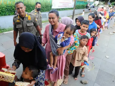 Warga antre untuk mendapatkan takjil di Jalan Raya Tegar Beriman, Cibinong, Kabupaten Bogor, Jawa Barat, Kamis (30/3/2023). (merdeka.com/Arie Basuki)