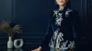 Dian Sastrowardoyo tampil mengenakan kebaya velvet warna navy dengan detail bordiran pita, dipadu kain batik sebagai bawahan dari Saptodjojokartiko. [@netflixid]