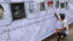 Warga membubuhkan tanda tangan pada spanduk bergambar tokoh nasional di area car free day, Jakarta, Minggu (14/5). Kegiatan tersebut sebagai bentuk tanggapan terhadap kondisi nasional terkait isu perpecahan dan perbedaaan. (Liputan6.com/Immanuel Antonius)