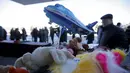 Balon berbentuk pesawat dan mainan diletakkan untuk mengenang korban jatuhnya pesawat maskapai Flydubai, di luar Bandara Rostov-on-Don, Rusia, Minggu (20/3). Insiden itu menewaskan seluruh penumpang dan kru yang berjumlah 62 orang (REUTERS/Maxim Shemetov)