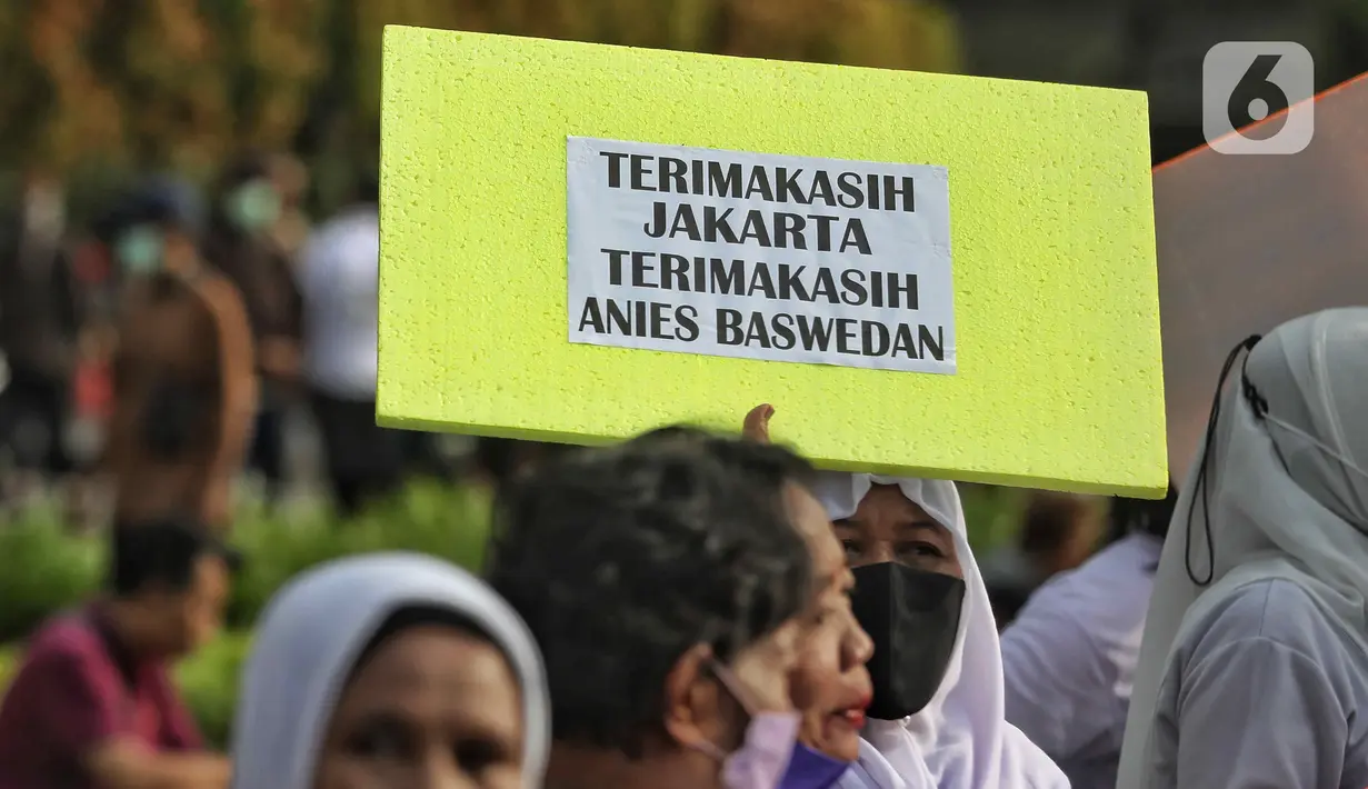 Warga membawa tulisan bertuliskan terimakasih Anies Baswedan di kawasan Bundaran HI, Jakarta, Minggu (16/10/2022). Hari terkahir menjabat sebagai Gubernur, Anies berkeliling dengan sepeda menuju Balai Kota. (Liputan6.com/Angga Yuniar)