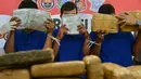 Para tersangka memperlihatkan paket ganja kering saat rilis kasus di Banda Aceh, Aceh, Kamis (23/5/2019). Satresnarkoba Polresta Banda Aceh mengamankan satu ton paket ganja, tiga tersangka dan satu unit truk tronton saat akan membawa narkotika ke Jakarta. (CHAIDEER MAHYUDDIN/AFP)