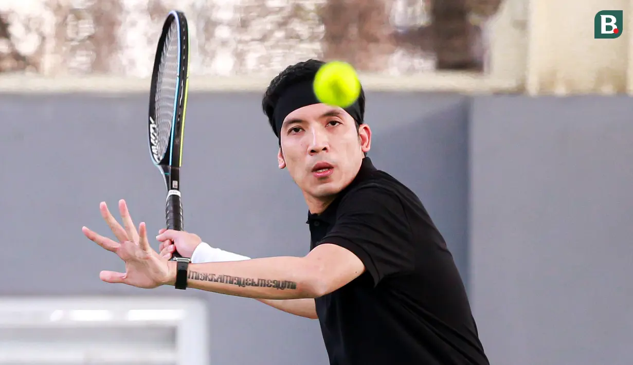 Selebritas Indonesia, Deddy Mahendra Desta berusaha mengembalikan bola ke arah pasangan Rezky Aditya dan Tanta Ginting pada laga tenis nomor ganda putra Turnamen Olahraga Selebriti Indonesia di GOR UNJ, Jakarta, Minggu (30/07/2023). Desta yang berpasangan dengan Raffi Ahmad menang dengan skor 4-6, 6-4, dan 6-4. (Bola.com/Bagaskara Lazuardi)
