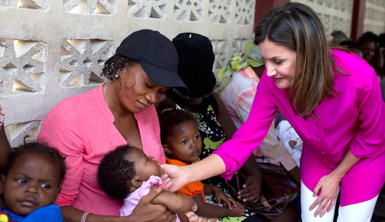 Ratu Spanyol Letizia menyapa seorang bayi perempuan dalam kunjungannya ke rumah sakit di daerah kumuh Soleil, Haiti, 23 Mei 2018. Ini merupakan kunjungan pertama Ratu Letizia ke negara termiskin di benua Amerika tersebut. (AP/Dieu Nalio Chery)