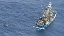 Kapal nelayan menyelamatkan perahu pengangkut tujuh penumpang selamat kapal feri MV Butiraoi yang hilang di perairan Pasifik di Kiribati, Minggu (28/1). Mereka berhasil bertahan hidup tanpa air maupun peralatan komunikasi. (New Zealand Defence Force/AP)