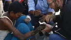 Pendiri Disaster Hack, Matthew Rockwell memasang tangan palsu buatan 3D ke lengan penderita kusta, Ram di Kathmandu (14/7). Tangan palsu yang dibuat dari mesin cetak 3 Dimensi (3D) jauh lebih murah dibandingkan tangan palsu Prostetis.(AFP Photo/Gopen Rai)