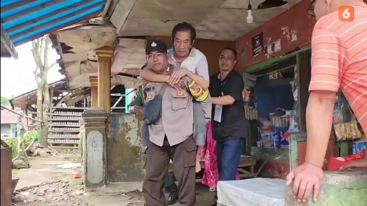 Bripka Deki menggendong seorang lansia Abah Edih (74) terpaksa digendong ke TPS karena mengidap penyakit stroke, di Kabupaten Sukabumi (Liputan6.com/Fira Syahrin).