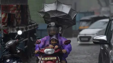 Pengendara melewati hujan di Mumbai, India, Minggu, 2 Juli 2023. Musim hujan India berlangsung Juni hingga September. (AP Photo/Rafiq Maqbool)