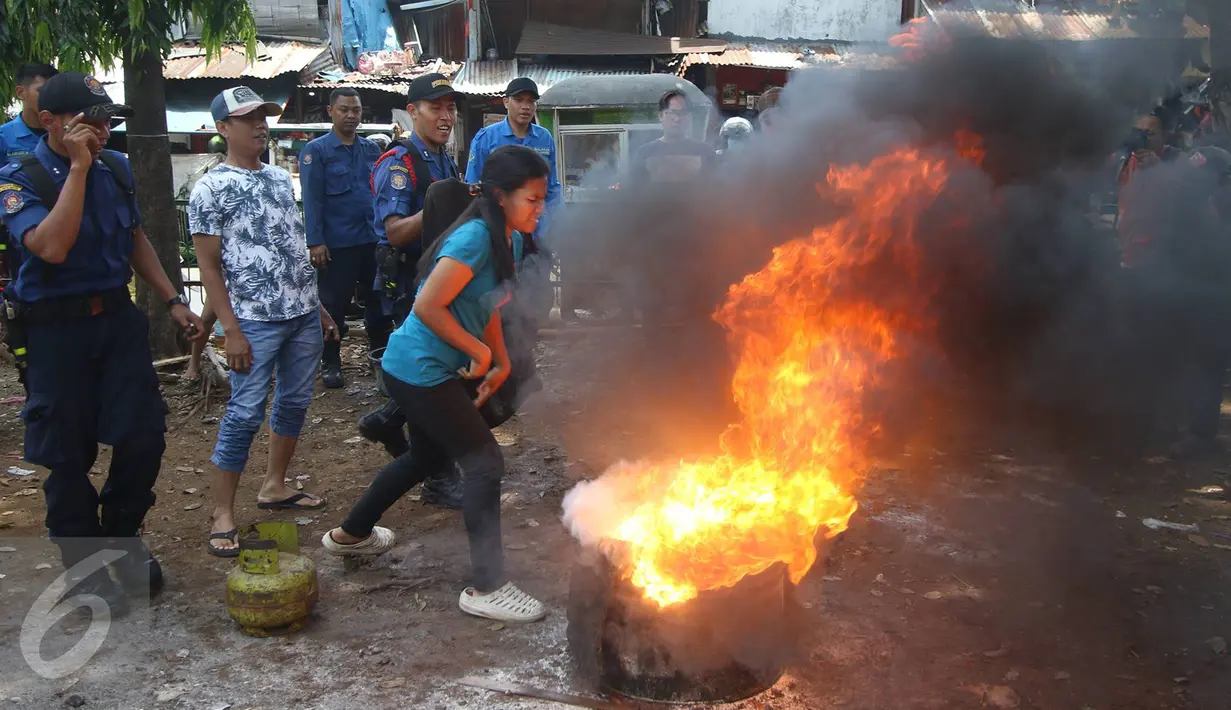 Warga mempraktekan materi yang telah diberikan petugas pemadam kebakaran, Jakarta, Minggu (9/10). Kegiatan ini dilakukan untuk mengedukasi warga tentang bagaimana langkah awal yang dapat dilakukan saat terjadi kebakaran. (Liputan6.com/Immanuel Antonius)
