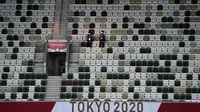 Polisi berdiri di tribun yang kosong sebelum upacara pembukaan Olimpiade Tokyo 2020 di Stadion Olimpiade, Tokyo, Jepang, Jumat (23/72021).  Upacara pembukaan Olimpiade Tokyo 2020 akan digelar pada 23 Juli 2021 malam. (Jewel SAMAD/AFP)