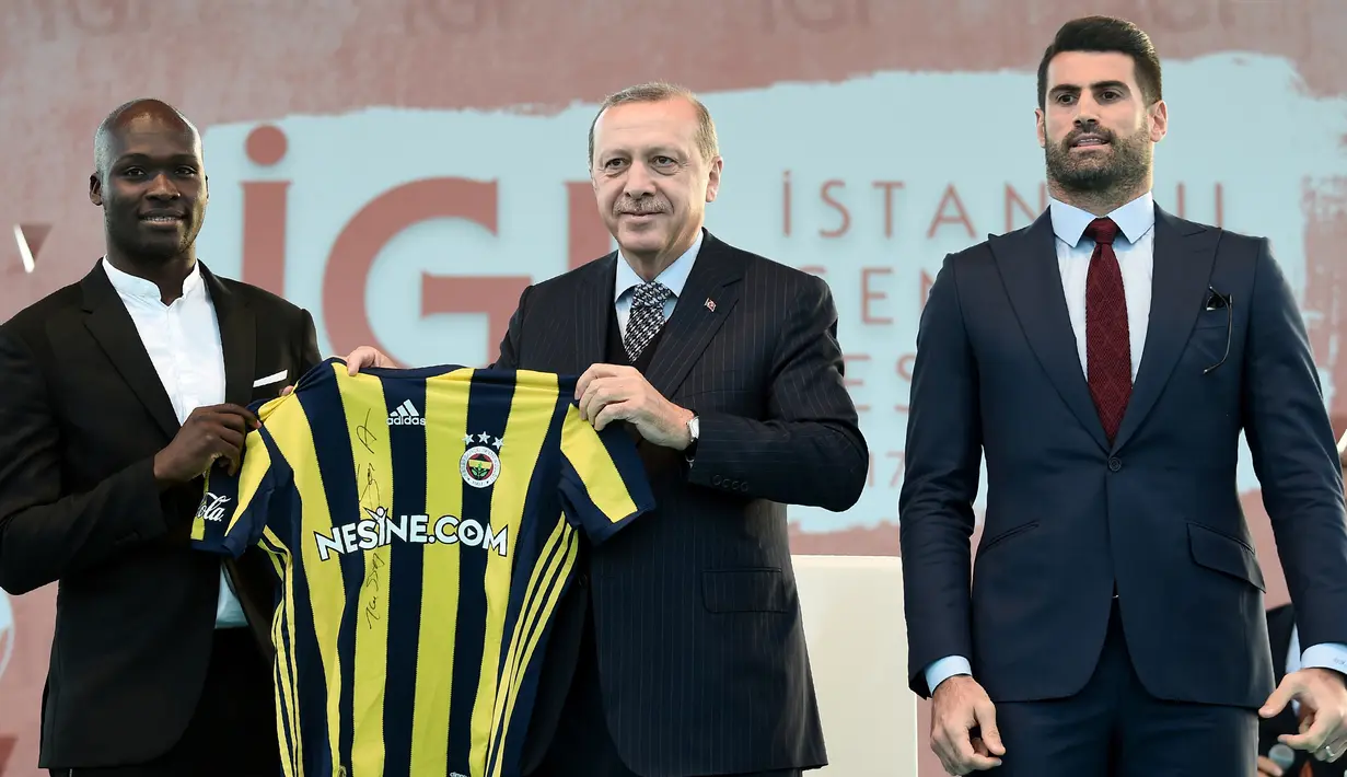 Presiden Turki, Recep Tayyip Erdogan (tengah) berpose ditemani pesepak bola dari Fenerbahce, Mousa Sow (kiri) dan Volkan Demirel (kanan) saat menghadiri Istanbul Youth Festival di Istanbul, Turki, Kamis (4/5). (AFP PHOTO / OZAN KOSE)