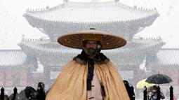 Seorang penjaga Kekaisaran berdiri di tengah salju di luar Istana Gyeongbok, istana kerajaan utama selama Dinasti Joseon dan salah satu landmark terkenal Korea Selatan di Seoul, Korea Selatan, 15 Desember 2022. (AP Photo/Ahn Young-joon)