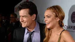 Charlie Sheen dan Lindsay Lohan saat akan menonton pemutaran perdana "Scary Movie 5" di Hollywood, AS. (11/4/2013). Dalam acara televisi Today yang disiarkan NBC pada Selasa (17/11/2015) Charlie Sheen mengaku mengidap HIV. (AFP Photo)