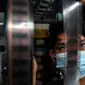 Adul (29) mengecek kualitas film seluloid 35mm untuk pertunjukan layar tancap di gudang rumahnya di Jakarta, Rabu (28/4/2021). (Liputan6.com/Johan Tallo)