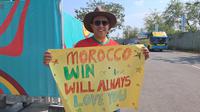 Aziz Mrabet membawa bendera Maroko, vas bunga, dan poster yang bertuliskan dukungan untuk timnas Maroko di Piala Dunia U-17 2023. (Bola.com/Muhammad Adi Yaksa)