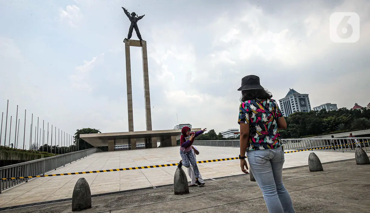 Warga berpose untuk foto di Taman Lapangan Banteng, Jakarta, Minggu (18/10/2020). Taman Lapangan Banteng dibuka pukul 06.00 sampai 17.00, khusus bagi masyarakat yang akan berolahraga. (Liputan6.com/Faizal Fanani)