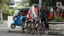 Pengojek sepeda berbincang sambil mencari penumpang di kawasan Pasar Asemka, Jakarta, Selasa (21/4/2020). Penghentian sementara aktivitas sebagian besar pertokoan dan perkantoran seiring WFH dan PSBB berimbas pada sulitnya pengojek sepeda mencari penumpang. (Liputan6.com/Helmi Fithriansyah)