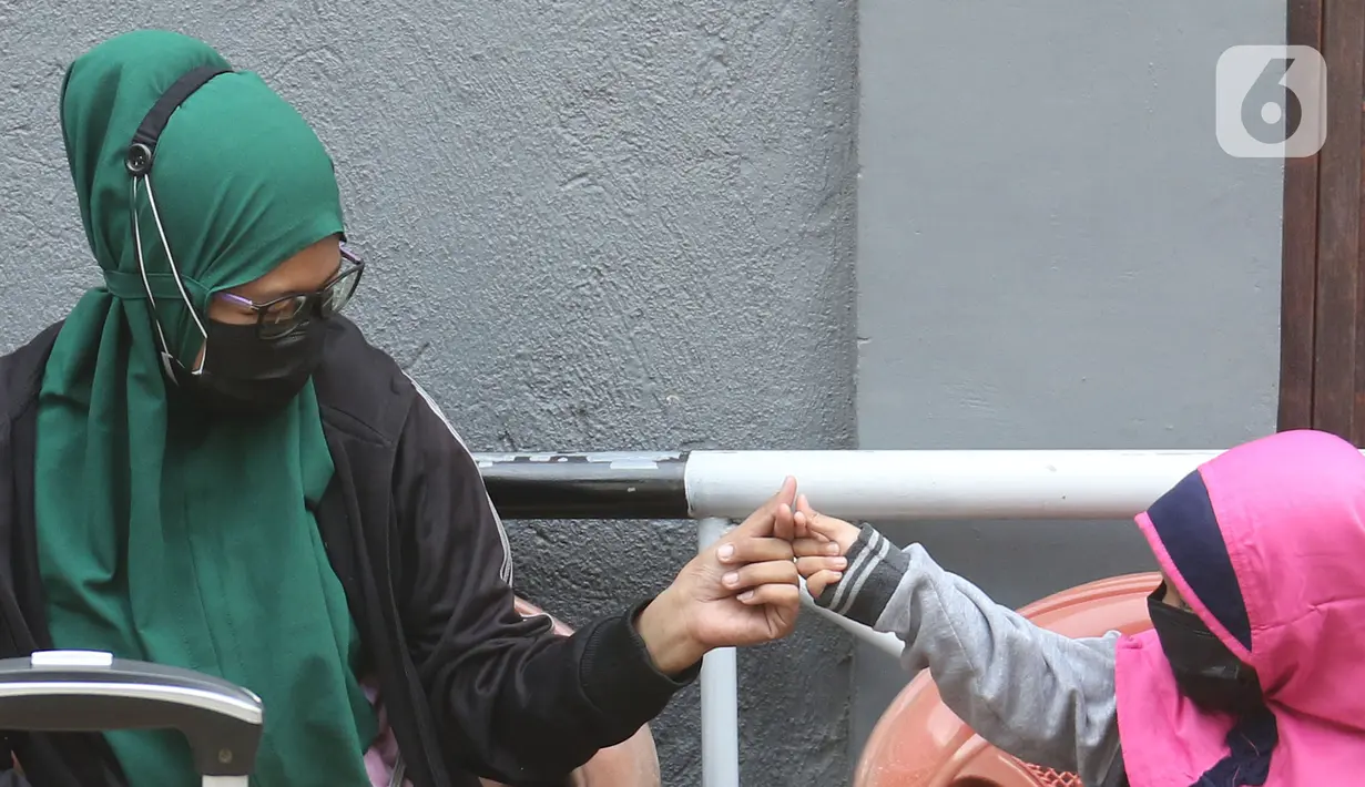 Warga saat akan dibawa ke wisma atlet di Jalan As-Syafiiyah, Cipayung, Jakarta, Jumat (21/5/2021). Klaster Halal Bihalal di Cipayung bertambah 32 orang dari 51 orang menjadi 83 orang terpapar COVID-19 perhari ini. (Liputan6.com/Herman Zakharia)