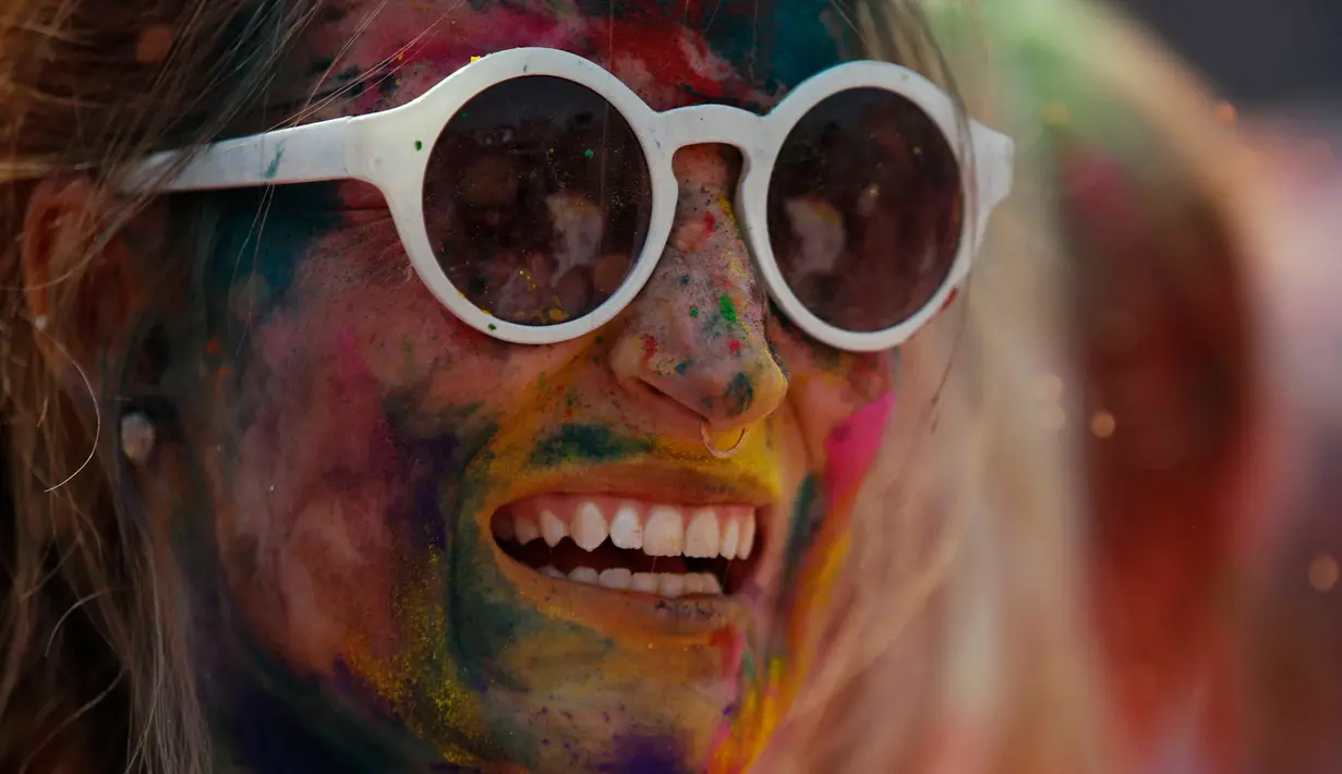 Seorang wisatawan ikut dalam merayakan Holi atau Festival Warna di Kathmandu, Nepal, 22 Maret 2016. Festival ini ramai didatangi wisatawan dan berlangsung selama 16 hari. (REUTERS / Navesh Chitrakar)