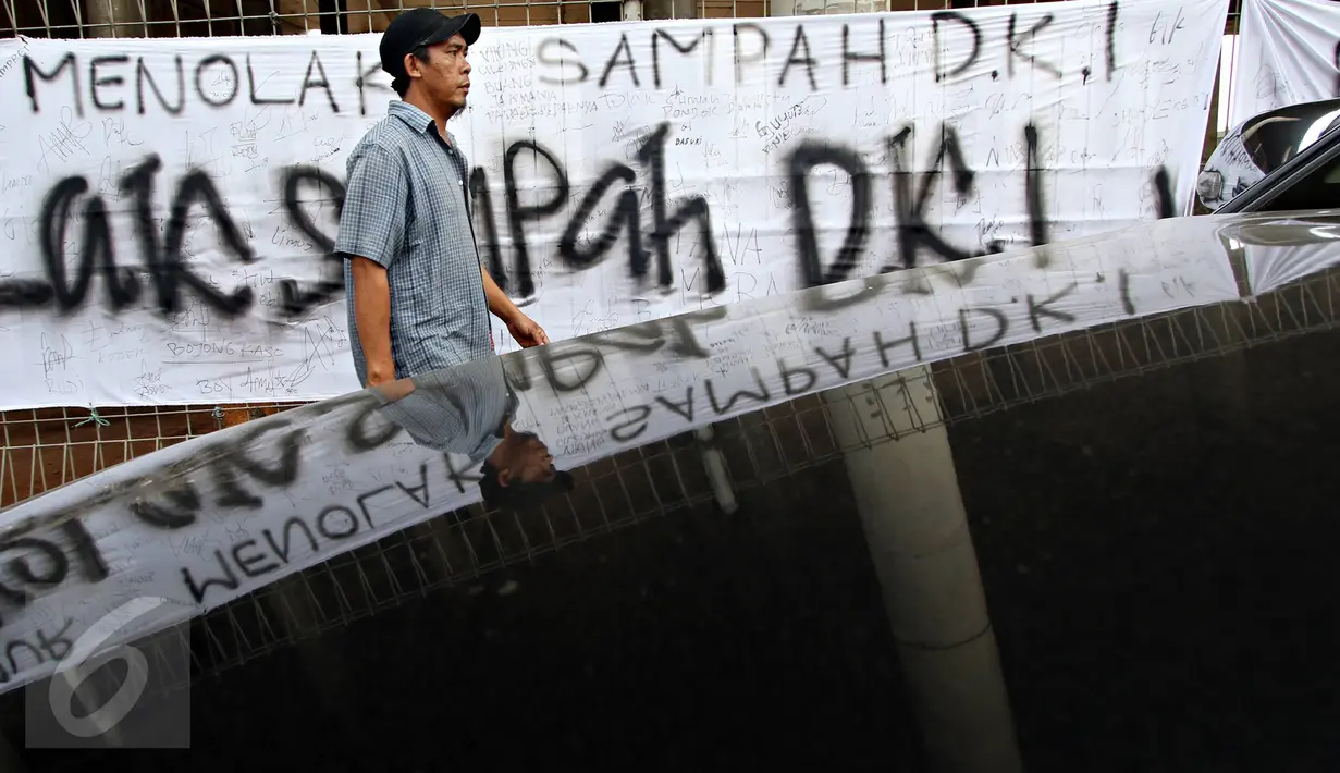 Warga melintas depan spanduk penolakan sampah DKI Jakarta di Jalan Raya Narogong, Bogor Timur, Jawa Barat, Rabu (4/11/2015). Ormas bersama warga menyatakan akan tetap menolak truk sampah yang melintas di kawasan tersebut. (Liputan6.com/Immanuel Antonius)