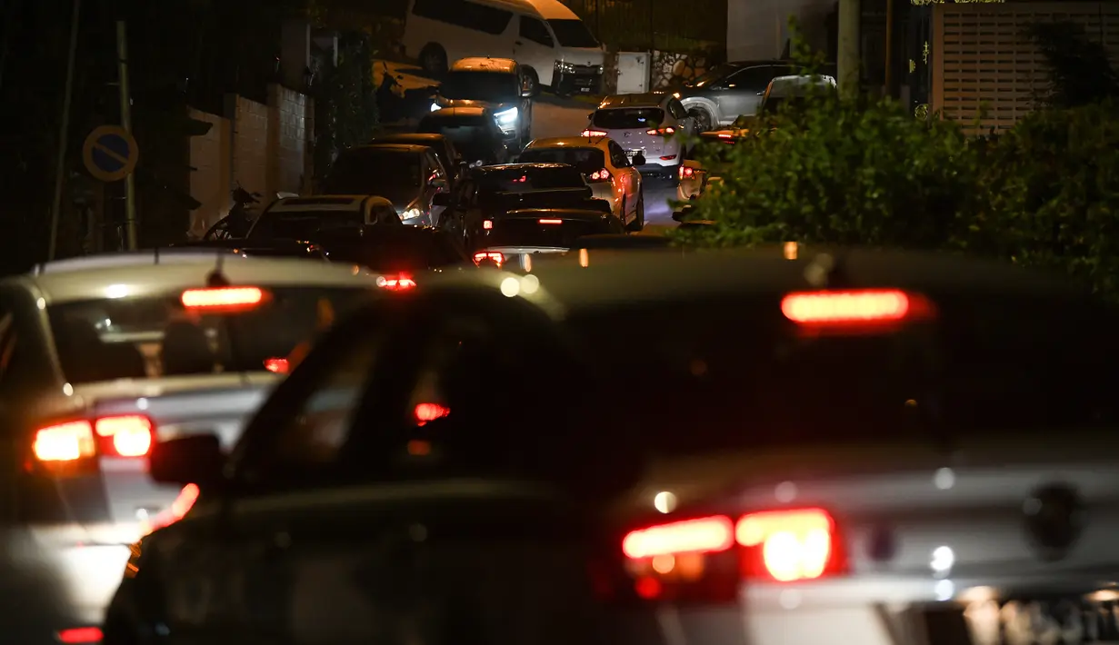 Sejumlah mobil polisi menuju rumah mantan Perdana Menteri Malaysia, Najib Razak di Kuala Lumpur, Rabu (16/5). Polisi melakukan penggeledahan di kediaman Najib usai Salat Tarawih untuk mencari bukti dan dokumen terkait kasus 1MDB. (AFP/Mohd RASFAN)