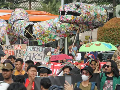 Aktivis yang tergabung dalam Orang Muda untuk Lingkungan Hidup (KOMUNAL) bersama WALHI saat karnaval menyambut Hari Lingkungan Hidup 2023 di Bundaran HI, Jakarta, Minggu (4/6/2023). (Liputan6.com/Angga Yuniar)
